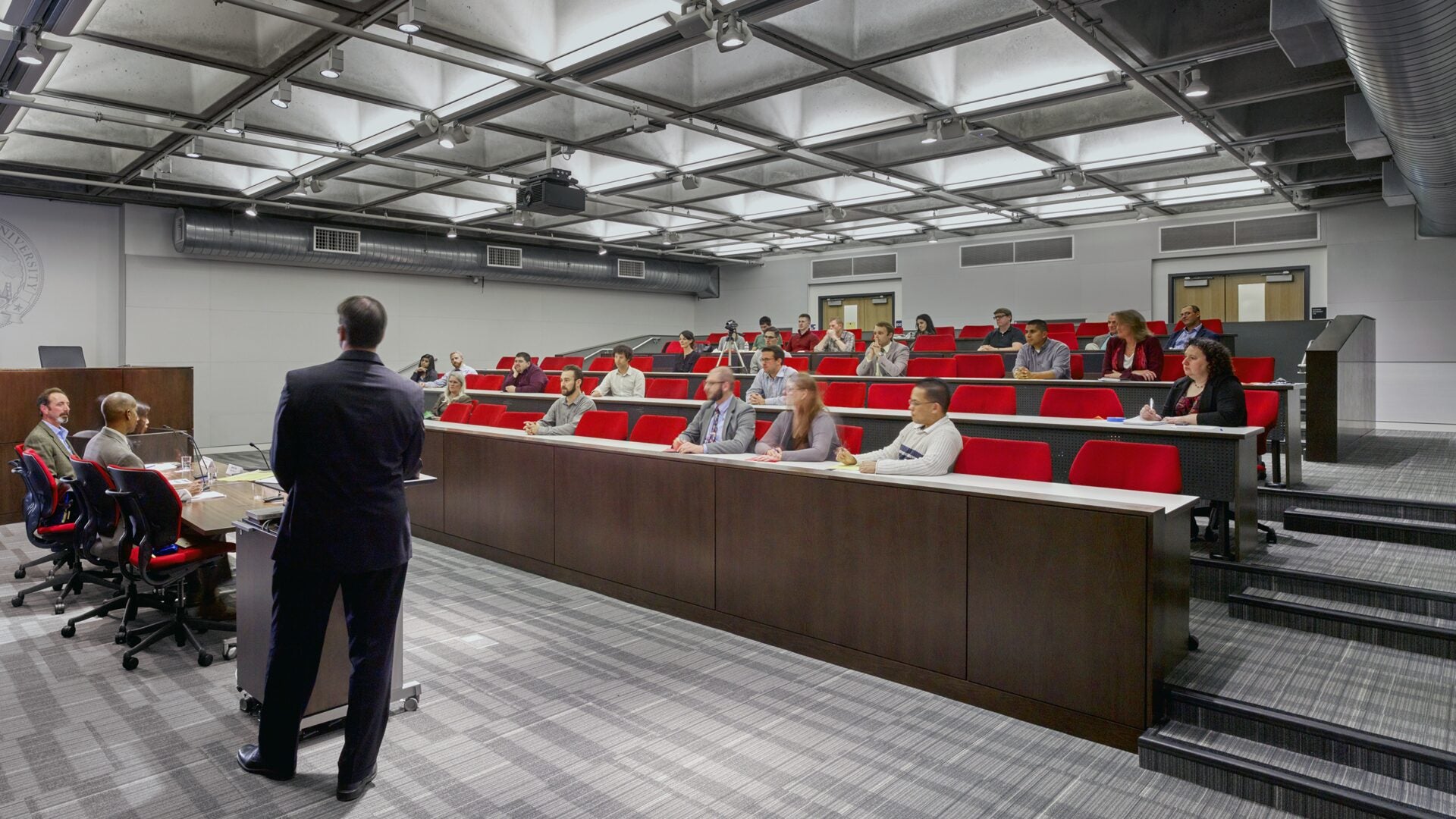 Students in a classroom listen to a presentation.